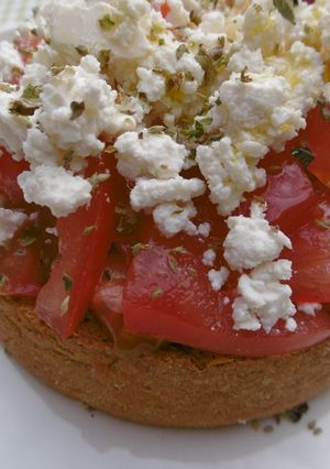 A picture of Traditional Cretan Barley Dakos with Feta Cheese and Tomatoes.