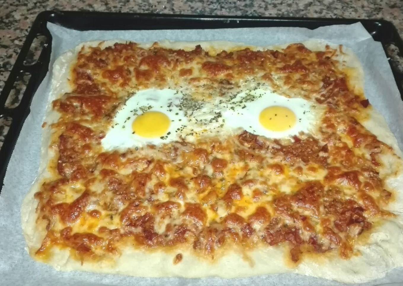 Pizza de masa fina con huevo, atún y jamón serrano