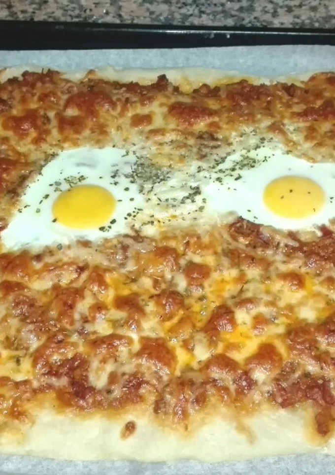Una foto de Pizza de masa fina con huevo, atún y jamón serrano