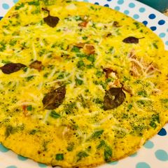 A picture of Spanish omelette with spinach and basil leaves.