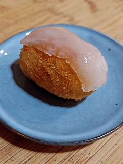 Una foto de Croquetas de pollo especiado en salsa con acelgas con velo de panceta ibérica