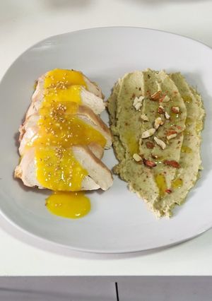 Una foto de Pechuga asada con salsa de naranja y hummus de alcachofa