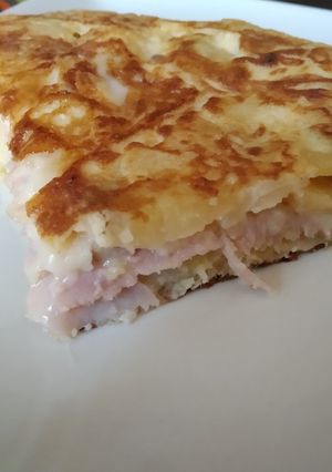 Una foto de Tortilla de patata rellena de queso y jamón york