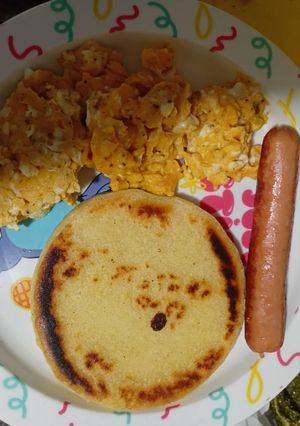 Una foto de Huevo revuelto con salchicha y arepa