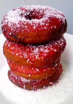 A picture of Red Glazed Eggless Doughnuts with Coconut.