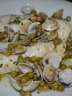 Una foto de Merluza con guisantes y almejas