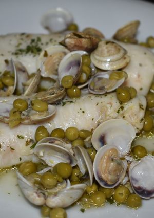 Una foto de Merluza con guisantes y almejas