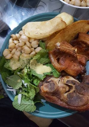 Una foto de Chicharrón de cerdo acompañado con mote papas