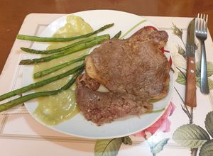 Una foto de Solomo con espárragos en gravy verde
