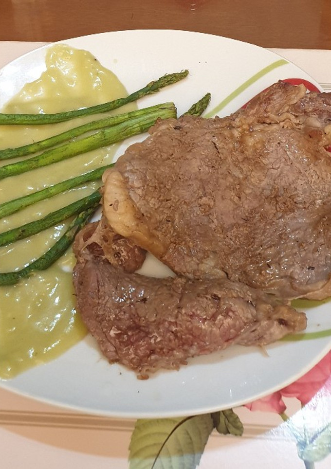 Una foto de Solomo con espárragos en gravy verde