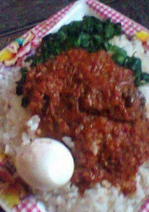 A picture of White rice with tomato sauce and vegetable.