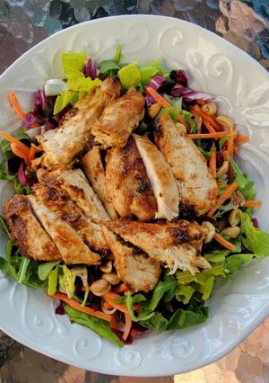 A picture of Kale Peanut Slaw w peanut vinaigrette plus peanut chicken.