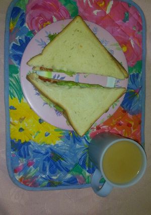 A picture of Tea with cinnamon and sandwich.