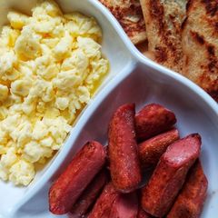 A picture of Homemade french toast, scrambled eggs and sausages.