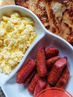 A picture of Homemade french toast, scrambled eggs and sausages.