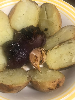 Una foto de Patatas, cebollas y ajos, todo asado en las brasas