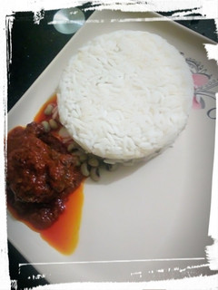 A picture of Rice/beans with palm oil stew.