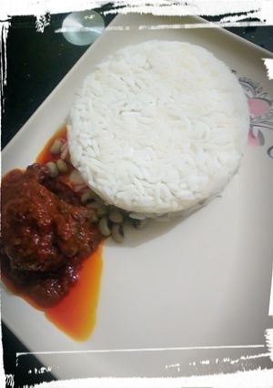 A picture of Rice/beans with palm oil stew.