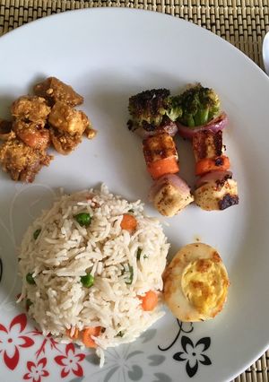 A picture of Veg Pulao with Kadai Paneer masala, boiled egg fry and grilled veggies with Paneer.