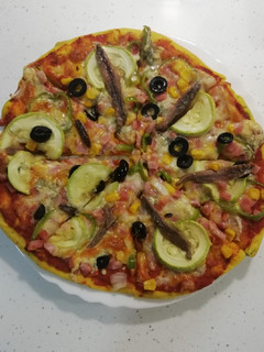 Una foto de Pizza de cúrcuma y semillas con verduras y anchoas