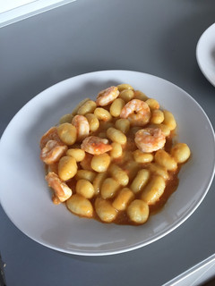 Una foto de Ñoquis en salsa de tomate cherry con gambas