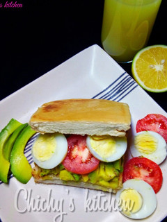 A picture of Avocado, tomato and egg sandwich.