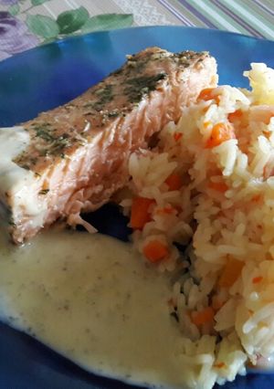 Una foto de Salmón rosado con arroz con verduras y salsa blanca