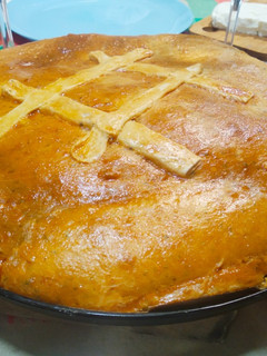 Una foto de Empanada de codillo de cerdo, cebolla caramelizada y pasas