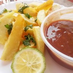 A picture of Potato wedges with tamarind chutney.