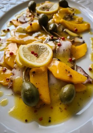 Una foto de Ensalada de pulpo y mango con pimienta rosa y alcaparrones