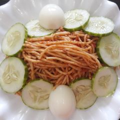 A picture of Spagetti with cucumber and egg.