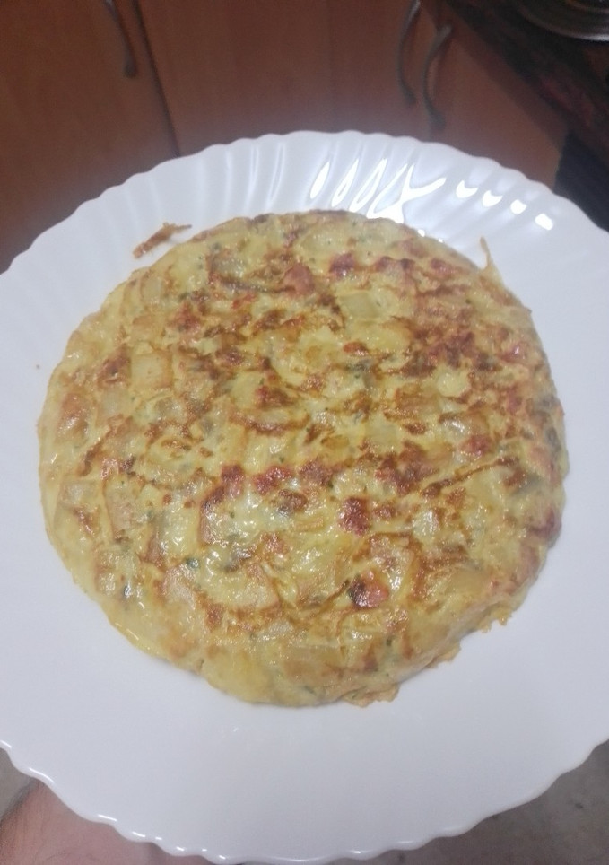 Una foto de Tortilla de papas con cebolla, chorizo y perejil