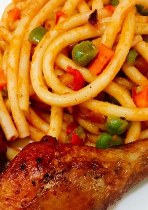 A picture of Veggy Pasta and fried chicken drumsticks.