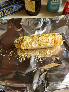 A picture of Corn on the cob grilled or baked.