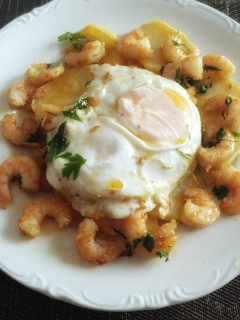 Una foto de Patatas con huevo frito y gambas al ajillo