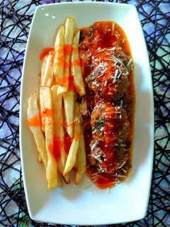 Una foto de Keftas hamburguesadas con queso y salsa de carne picada y tomate