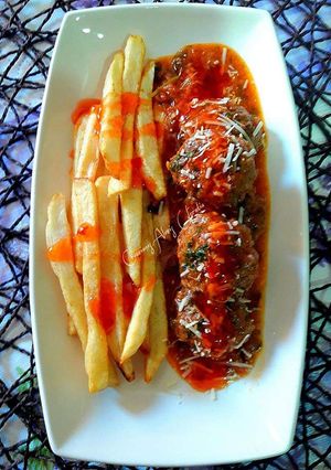 Una foto de Keftas hamburguesadas con queso y salsa de carne picada y tomate