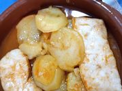 Una foto de merluza con patatas y pimentón