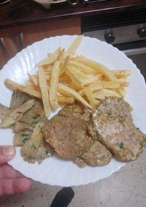 Una foto de Solomillo de cerdo a la plancha con setas al ajillo y papas fritas