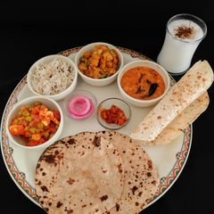A picture of NORTH INDIAN THALI For lunch mutter -paneer, aloo gobhi, moong dal tadka,jeera rice,pickle, roti.