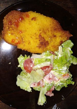 Una foto de Milanesa de pollo, con ensalada