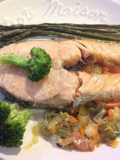 Una foto de Salmón con verduras sobre cama de tomate