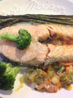 Una foto de Salmón con verduras sobre cama de tomate