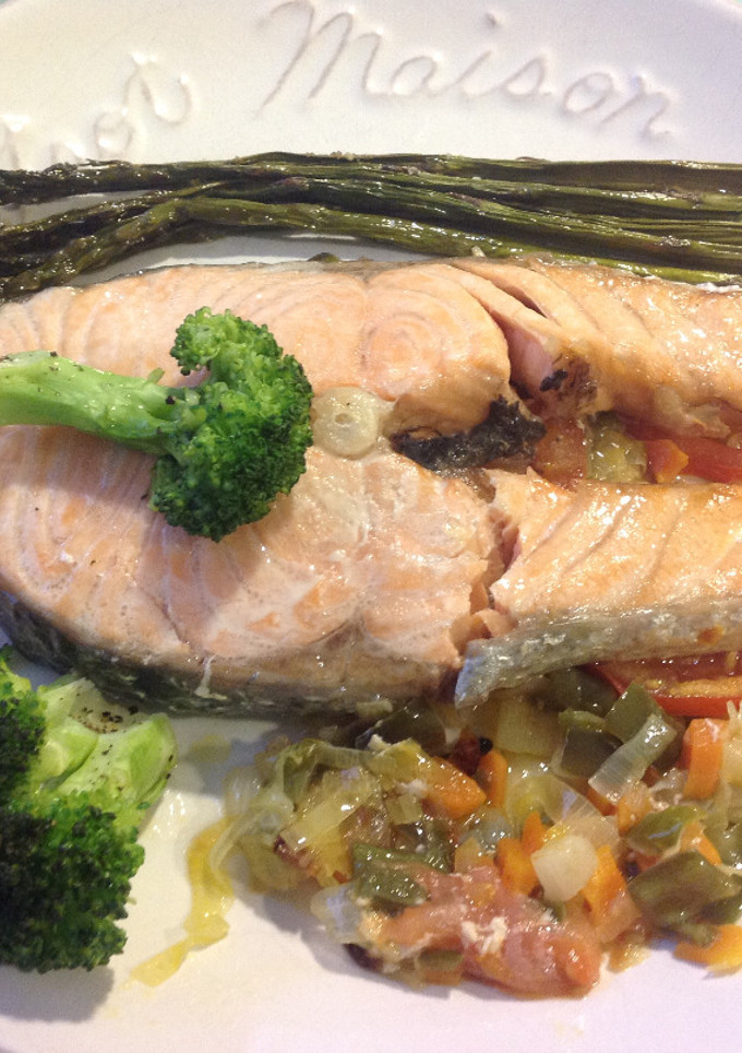 Una foto de Salmón con verduras sobre cama de tomate
