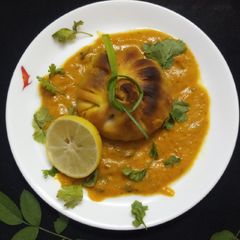 A picture of Baked paneer momos with gravy.