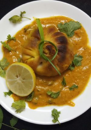 A picture of Baked paneer momos with gravy.