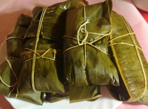 Una foto de Tamales (hayacas o pasteles) de maíz, pollo y cerdo con verduras