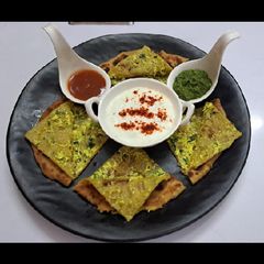 A picture of Mixveg paneer paratha with green chatny and curd.