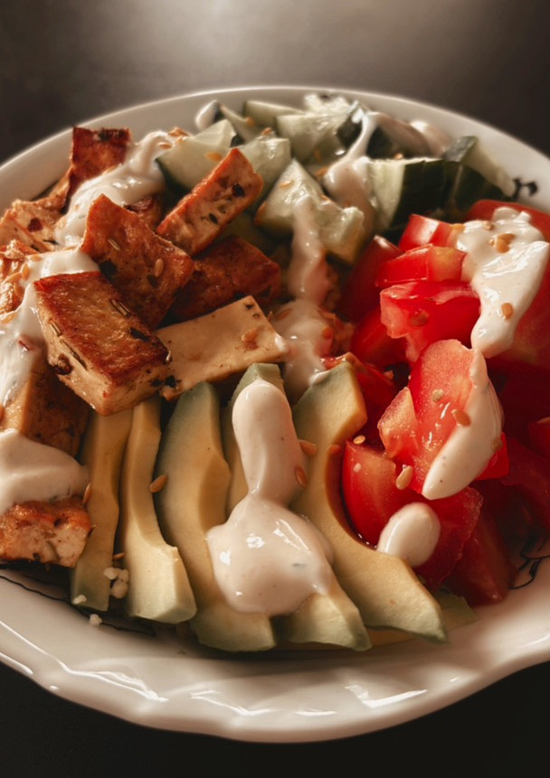 Una foto de 🌱 Couscous con tofu marinado, aguacate, pepino y tomate con salsa de yogurt casera 🌱