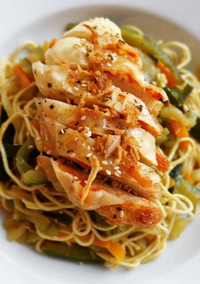 Una foto de Noodles con verduras al curry y solomillo de pollo a la parmesana